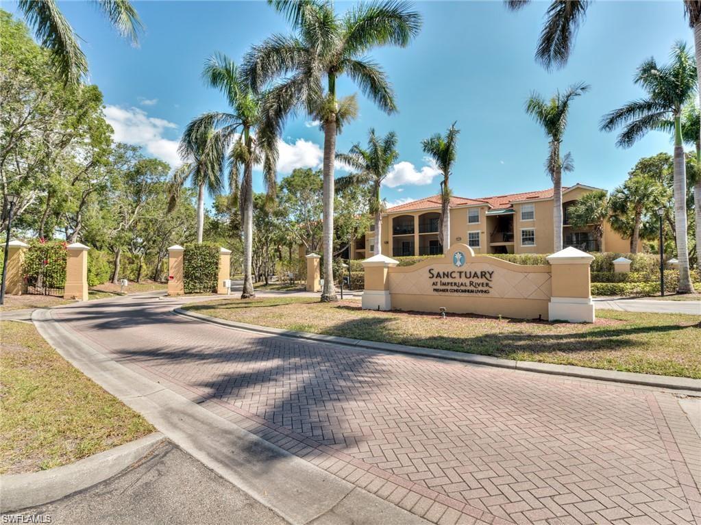 a view of a house with a yard and palm trees