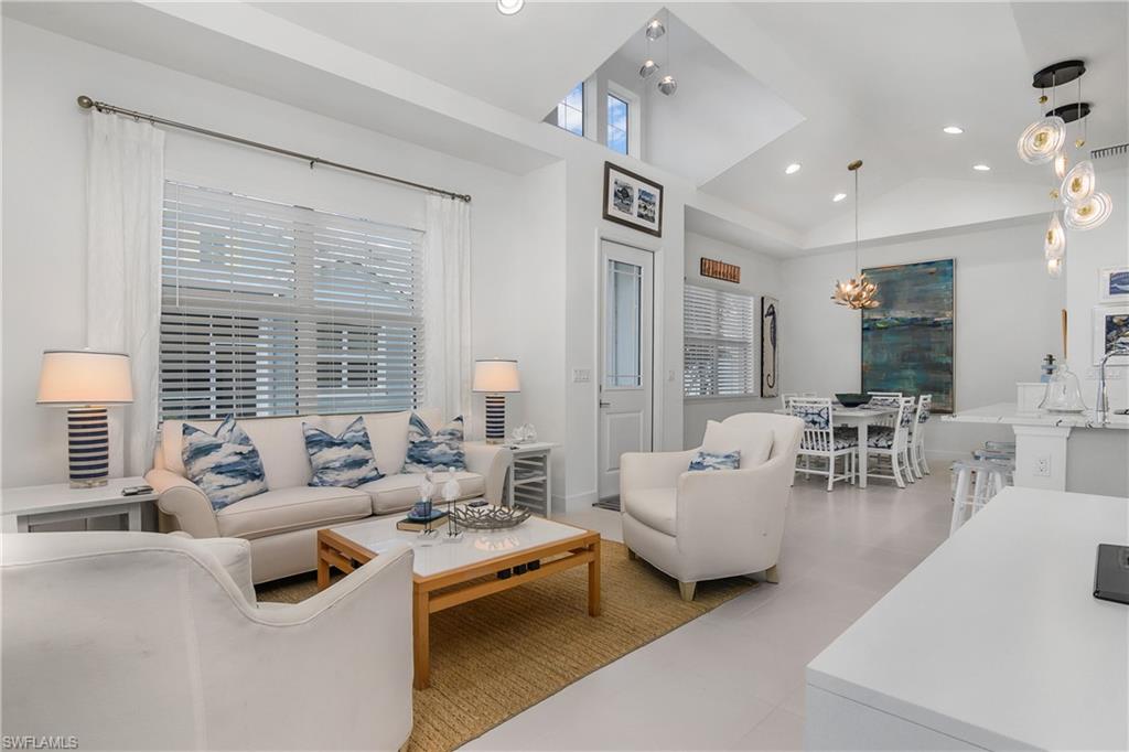 Living room featuring a chandelier and high vaulted ceiling, note the overhead windows.