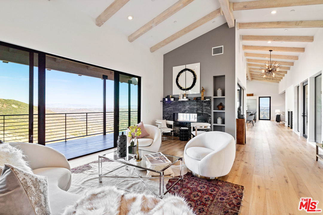 a living room with furniture a rug and a large window