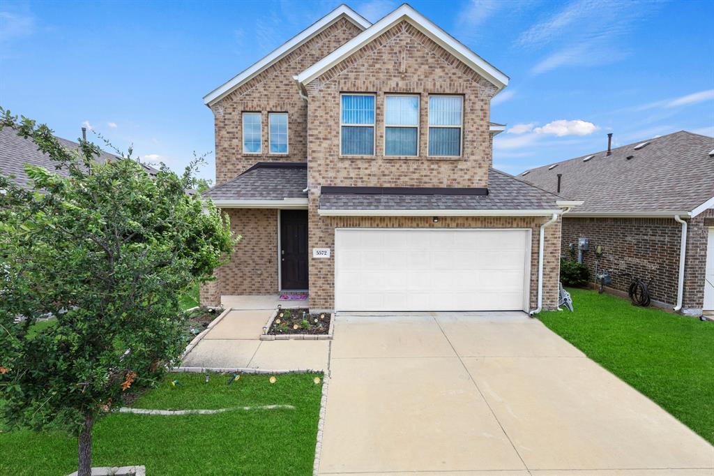 a front view of a house with a garden and yard