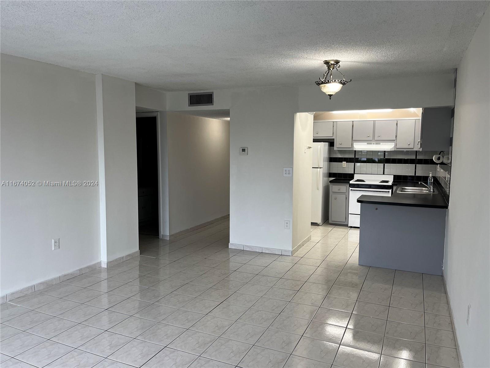 a view of kitchen with refrigerator and cabinets