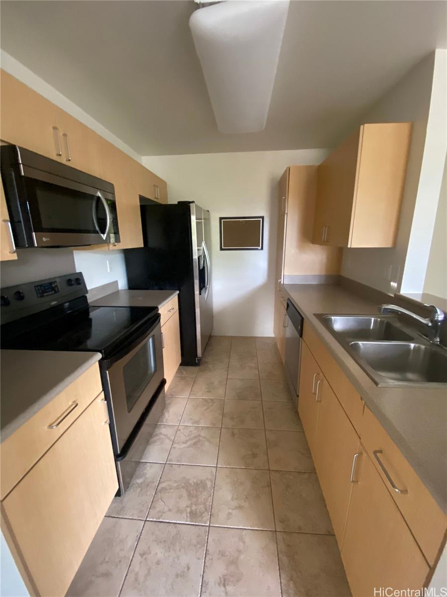 a kitchen with a sink a stove top oven and cabinets