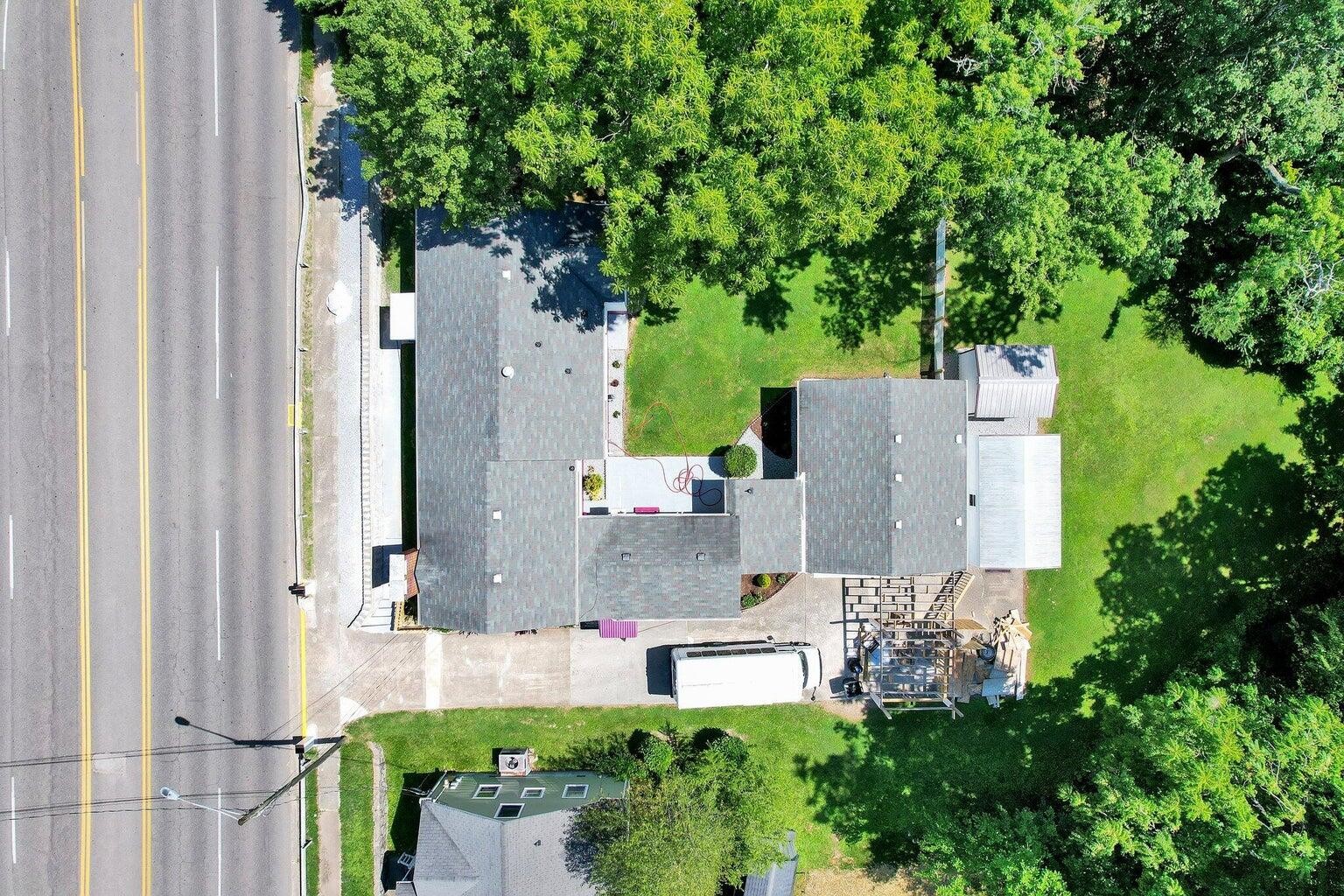 an aerial view of residential house with outdoor space and trees all around