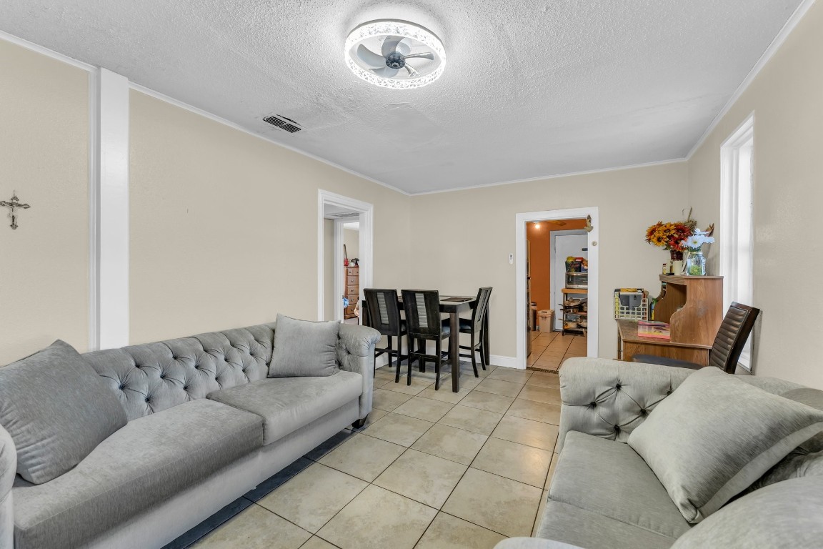 a living room with furniture and a dining table