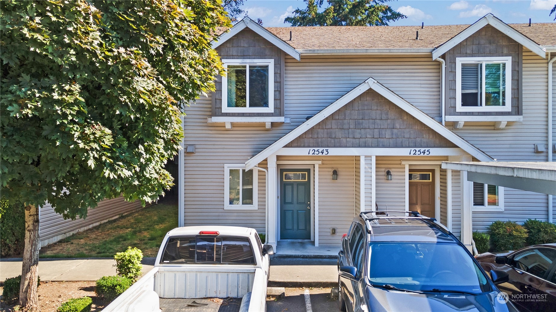 a front view of house with yard and car parked