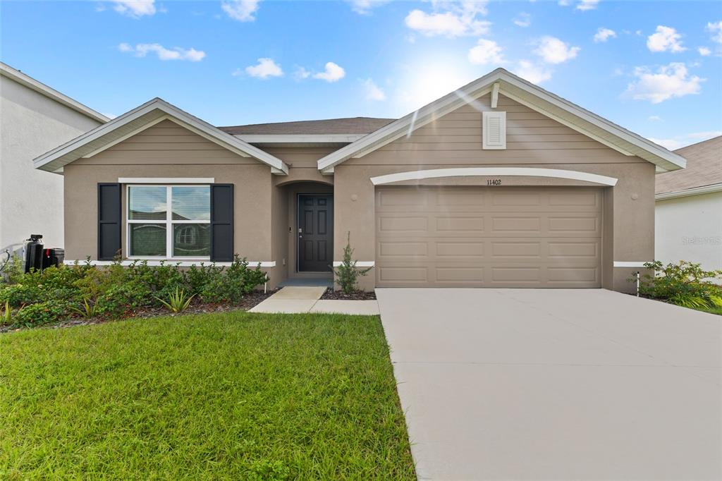 a front view of a house with a yard and garage