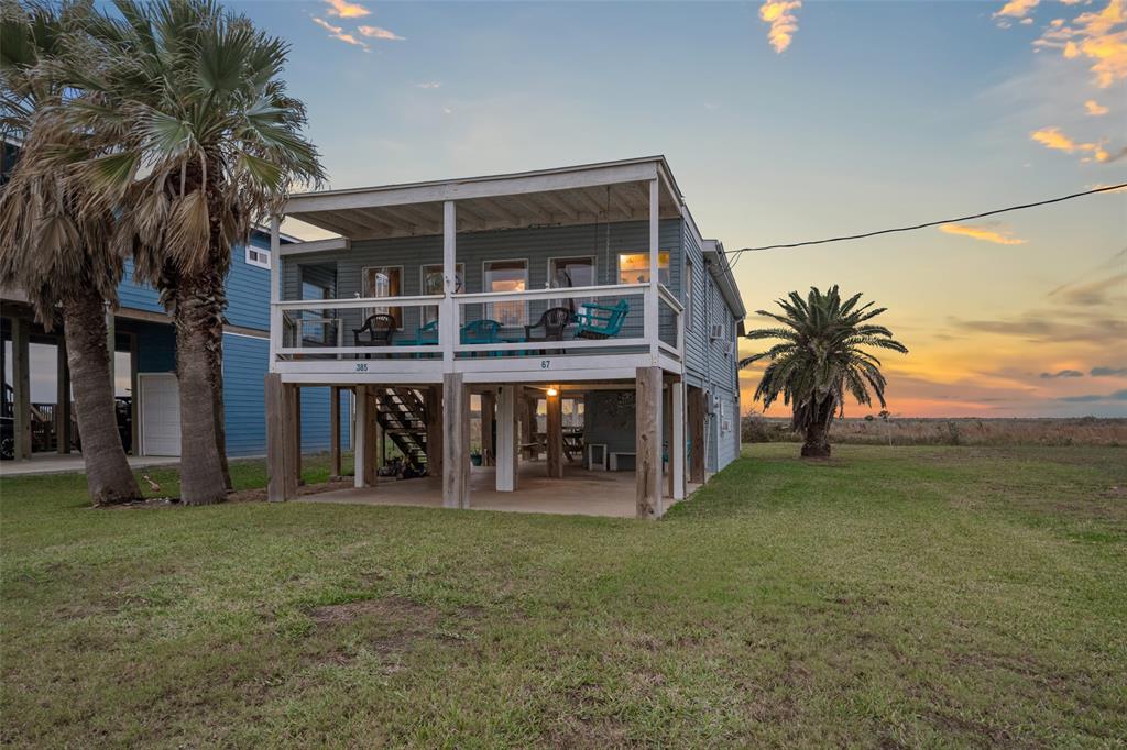 a view of a house with a patio and a yard