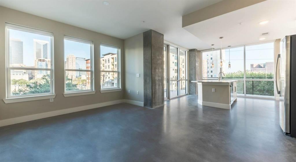 a view of a big room with wooden floor and windows