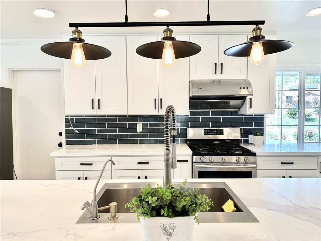 a kitchen with stainless steel appliances a stove a sink and cabinets