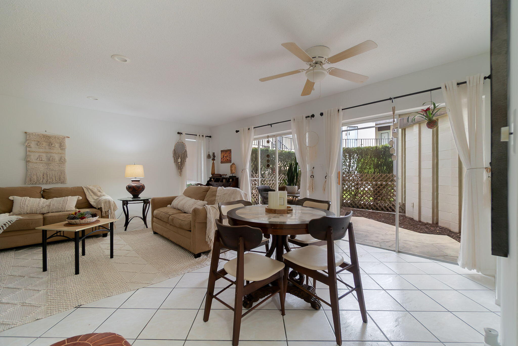 a living room with couches a table and a dining table with wooden floor