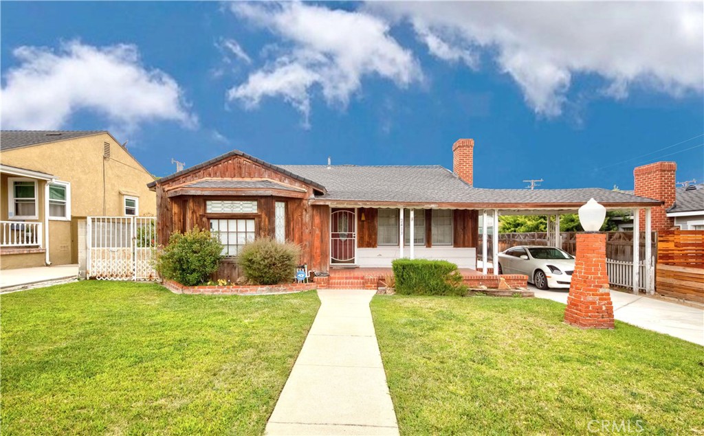 a front view of a house with garden and yard