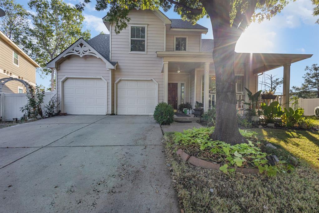 a view of a house with a yard and large tree