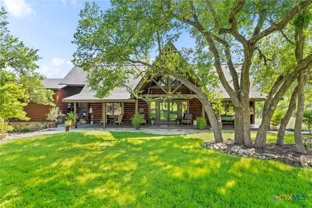 a view of a house with a big yard and large trees