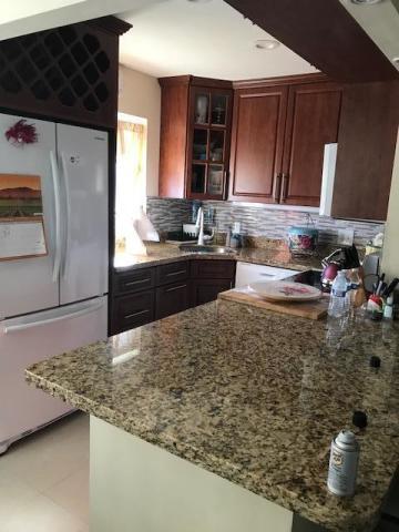 a kitchen with kitchen island sink stove and cabinets