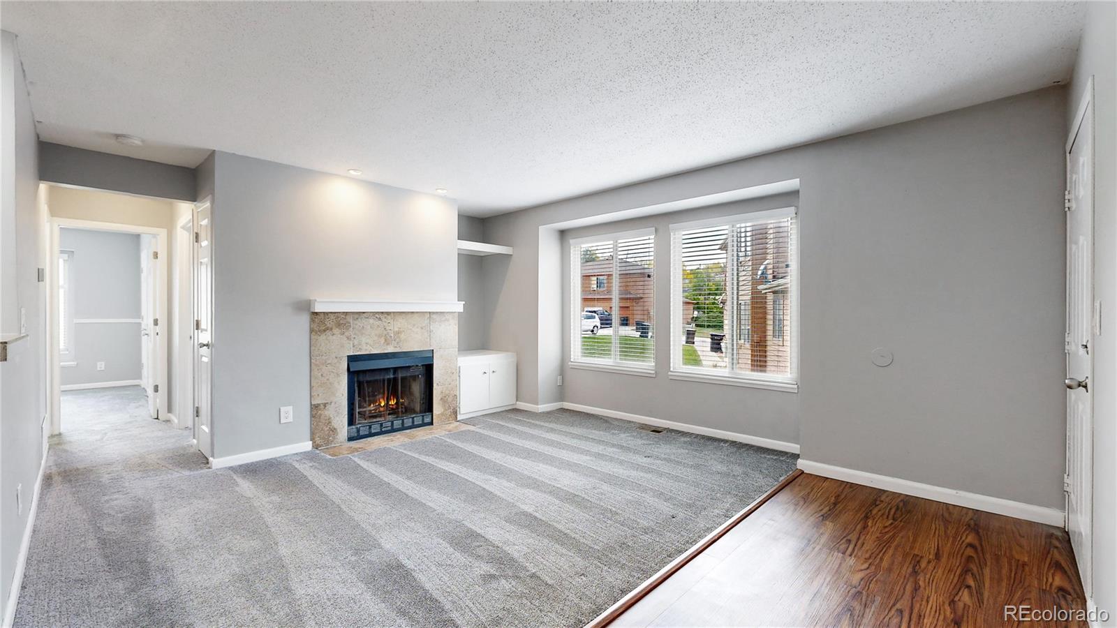 an empty room with windows and a fireplace