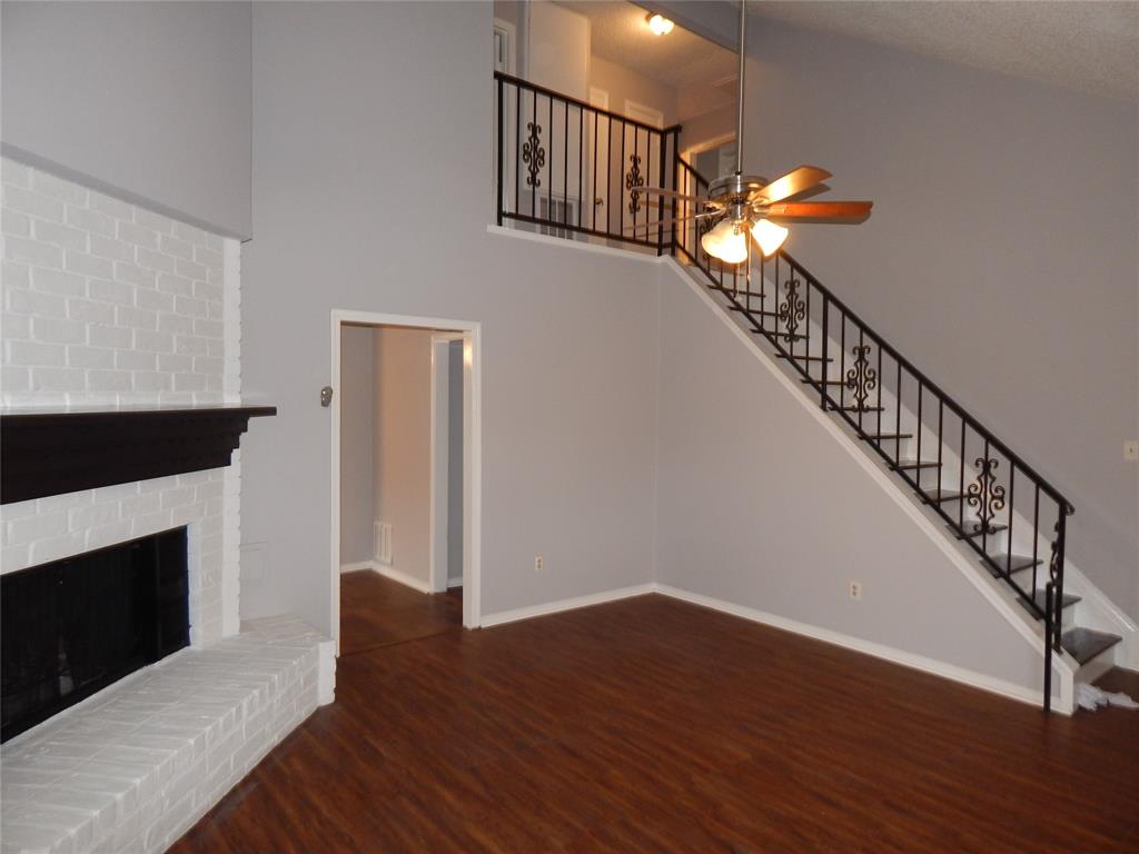 a view of staircase with wooden floor and a fireplace