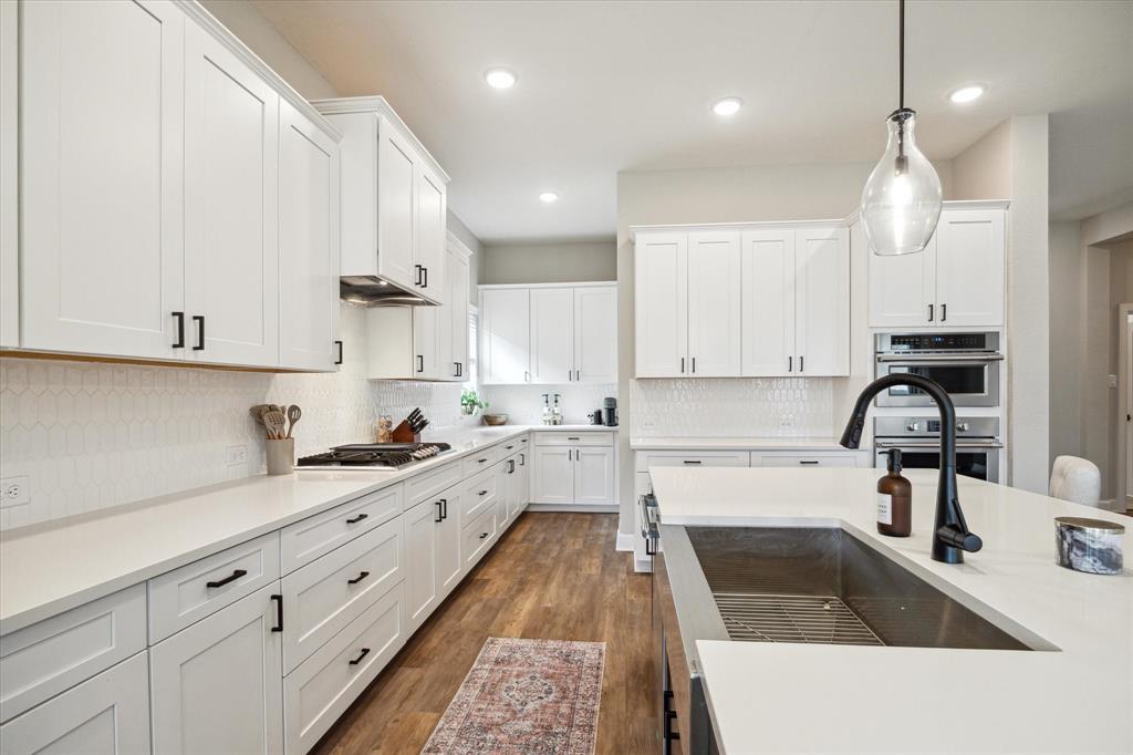 a kitchen with granite countertop a sink stainless steel appliances and cabinets