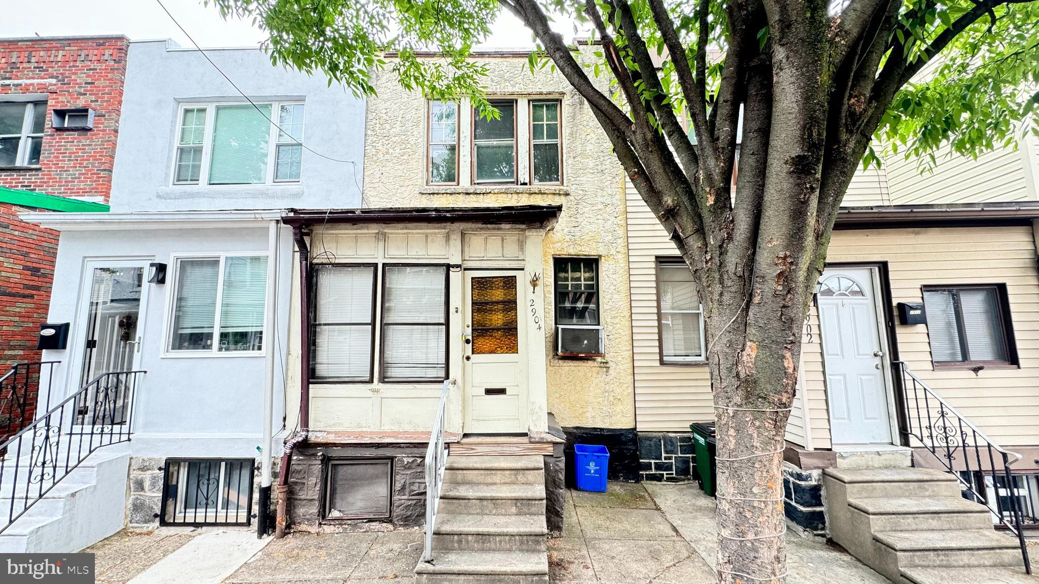 a front view of a house with a tree