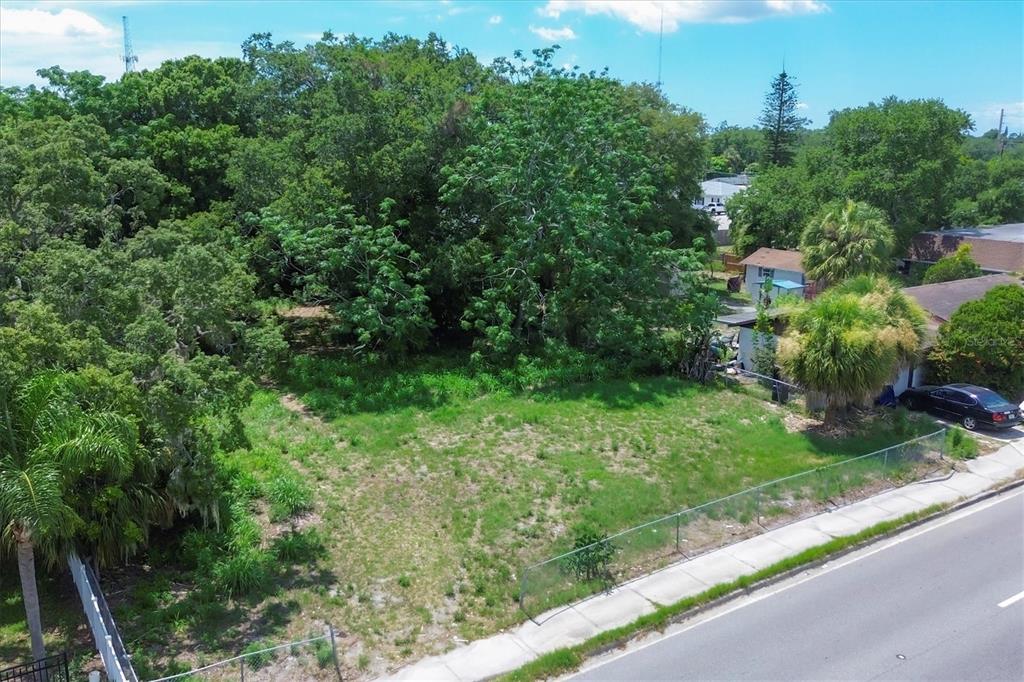 an aerial view of residential houses with outdoor space and trees