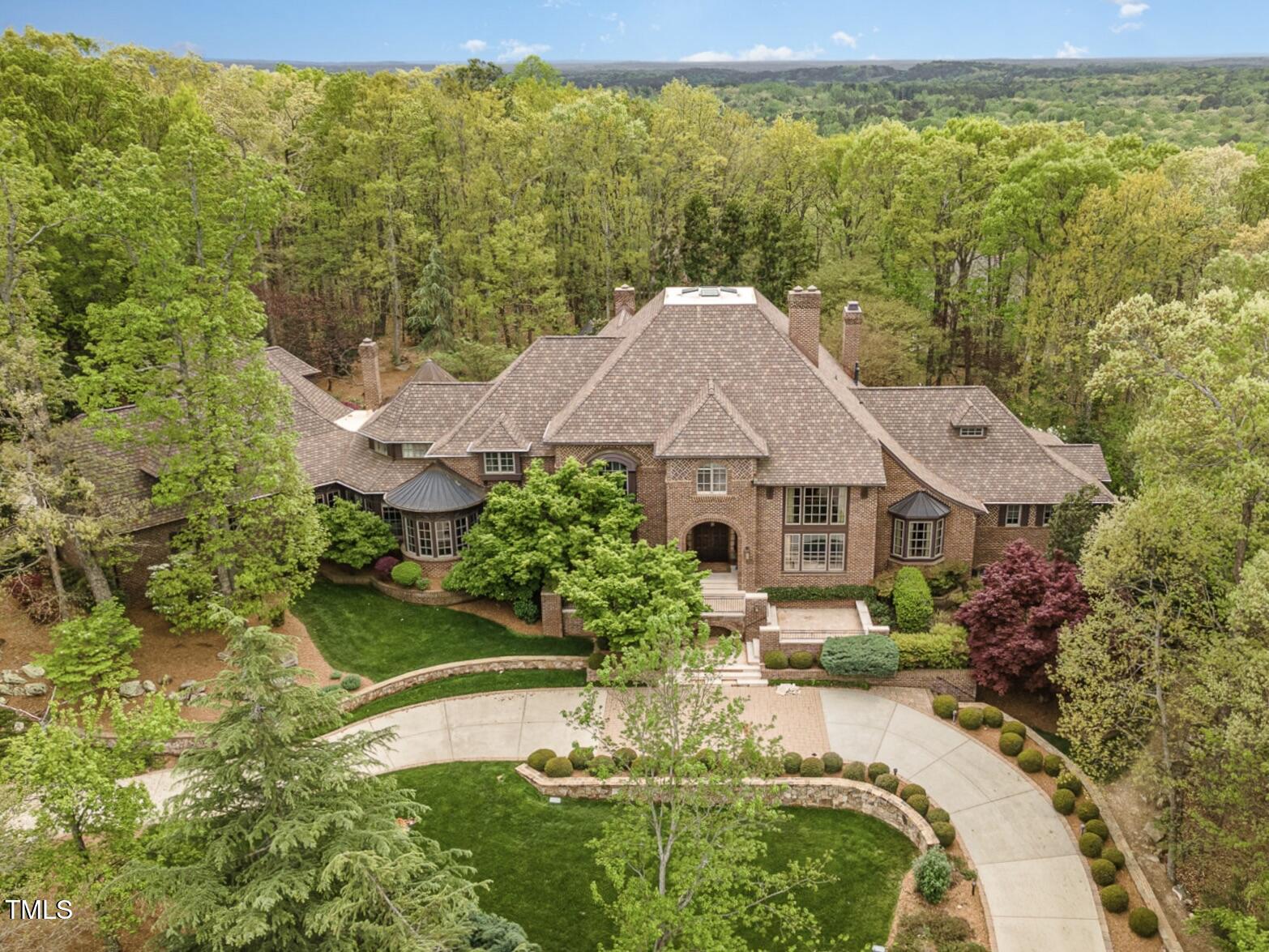 a aerial view of a house with a garden and lake view