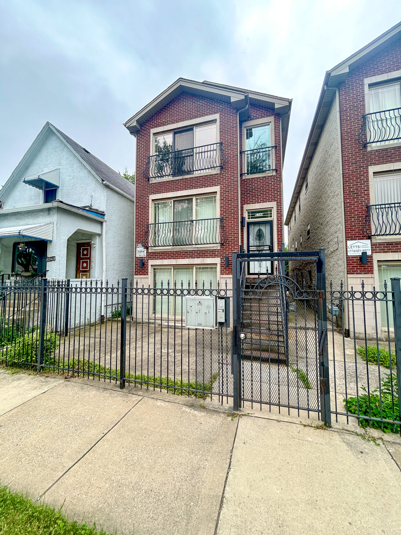 a view of front of a house with a iron gate