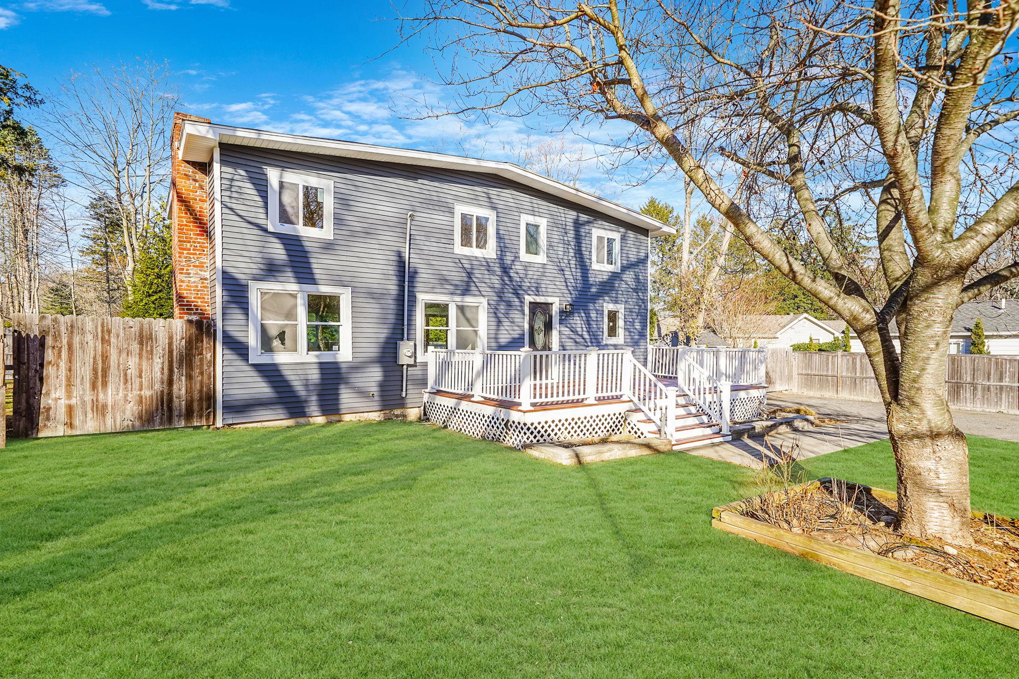 Back of house with a yard and a deck