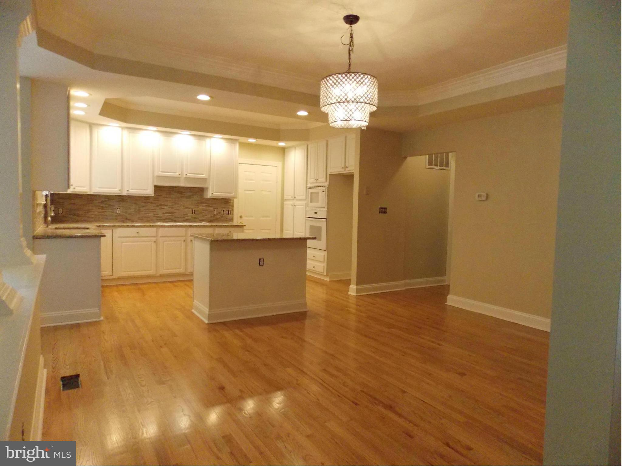 a view of a kitchen with a sink and wooden floor