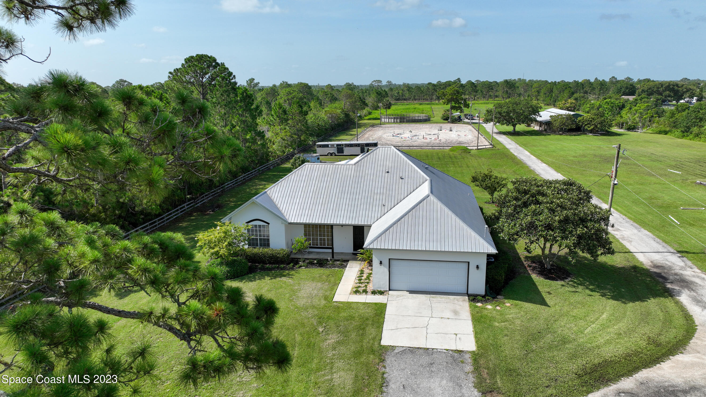 an aerial view of residential houses with outdoor space and trees