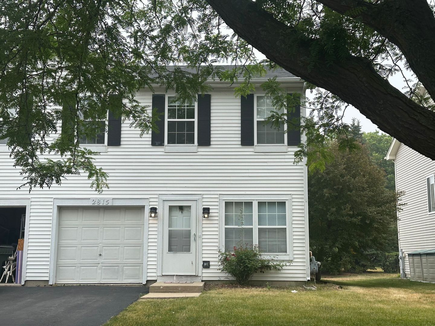 a front view of a house with a garden and trees