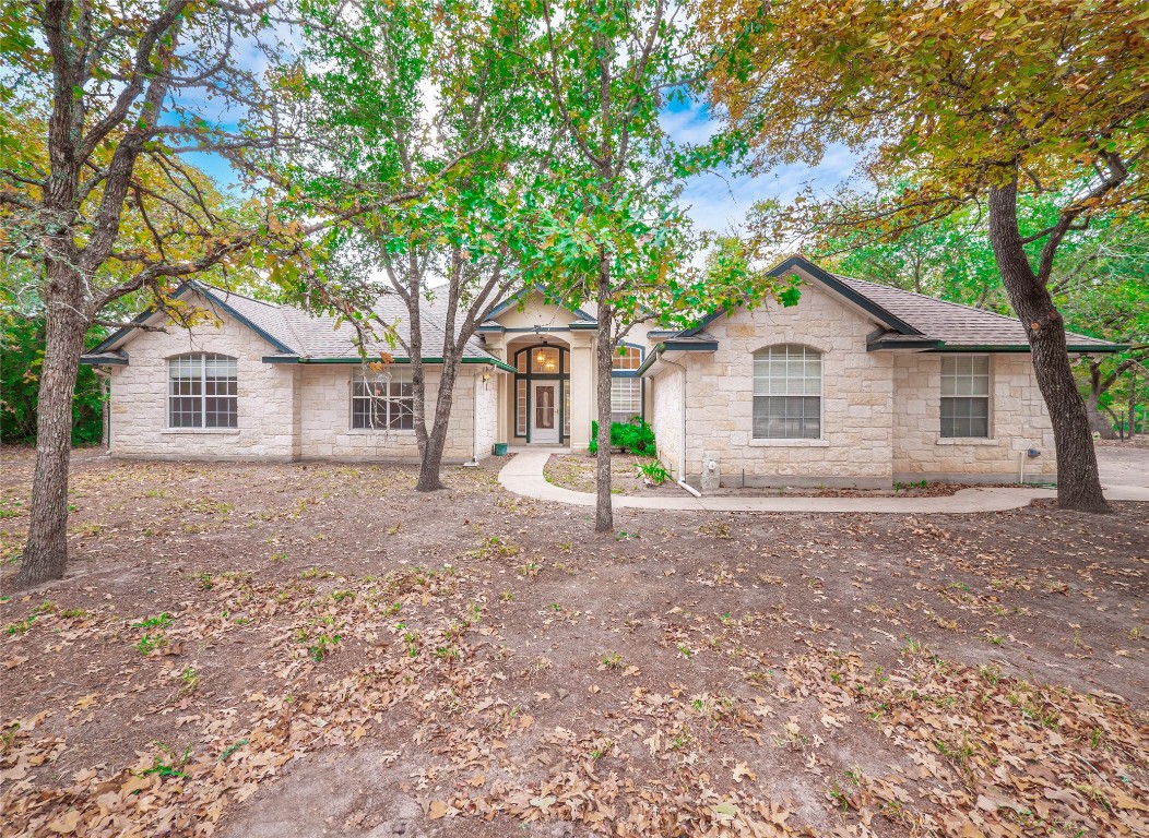 a view of a house with a yard and large tree