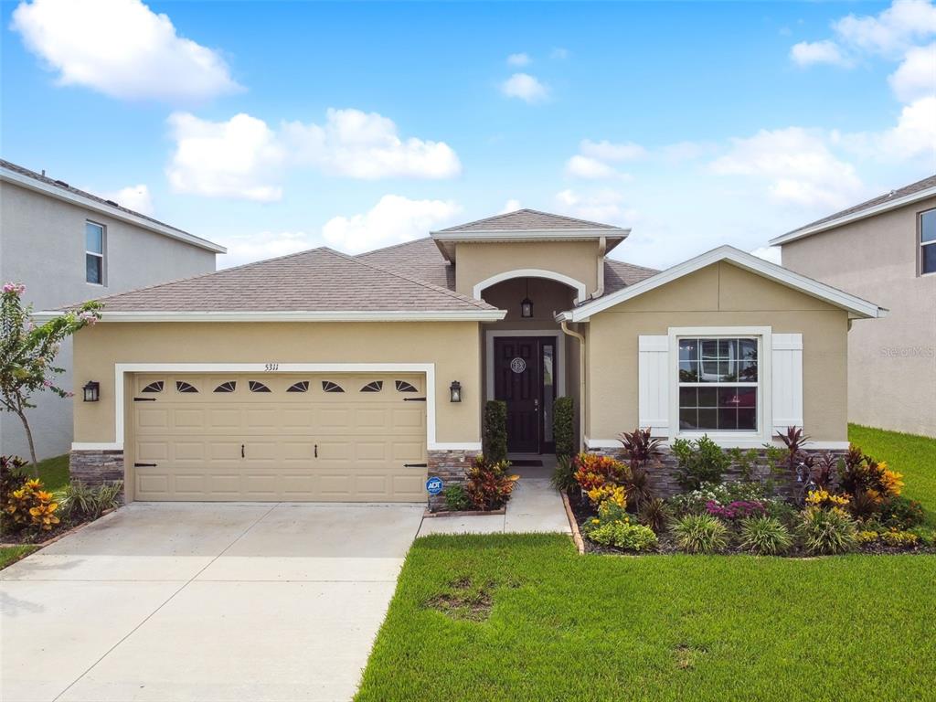 a front view of a house with a yard and garage