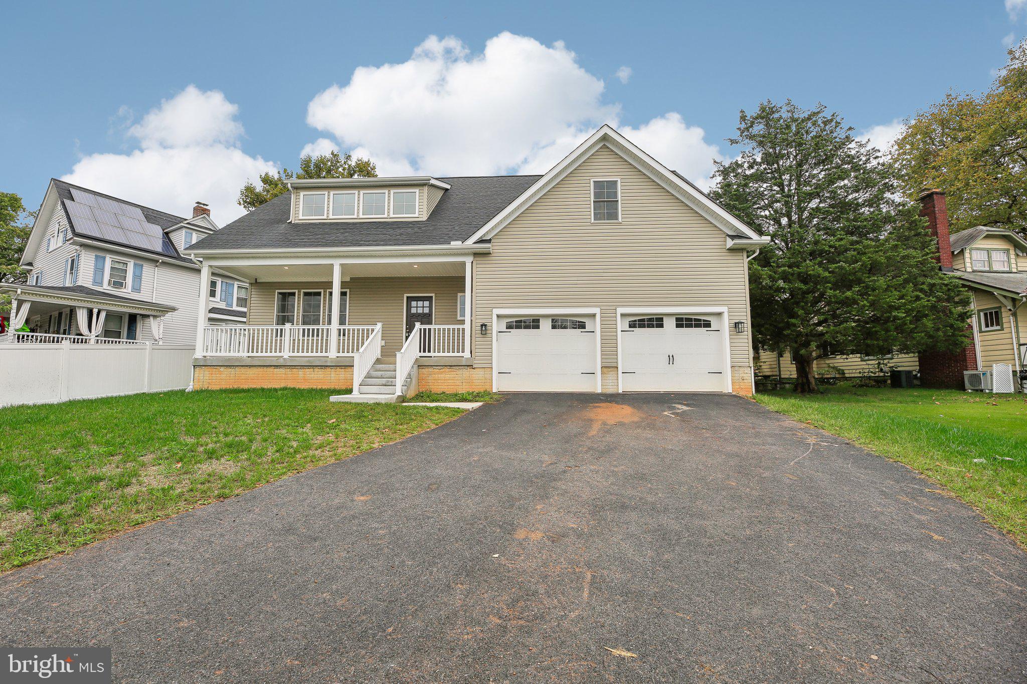 a view of a house with a yard and a large tree