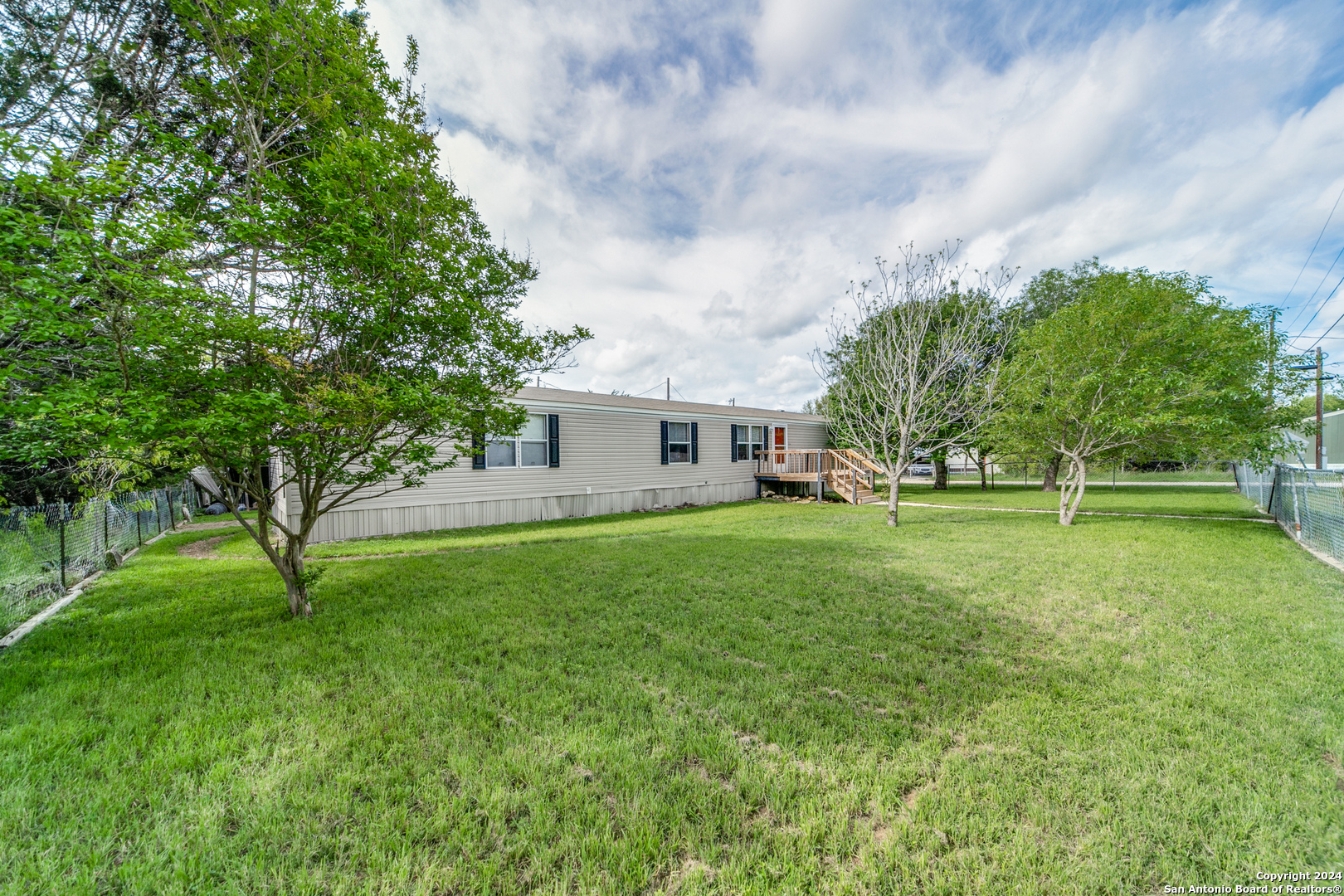 a view of a house with a big yard and a large tree