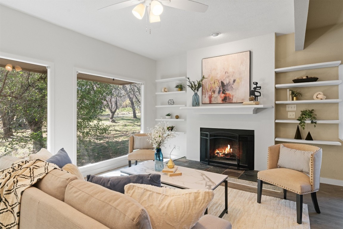 The living room invites you to sink into relaxation with its cozy fireplace, where floating shelves offer space to display treasured finds, adding a personal touch that feels both welcoming and serene