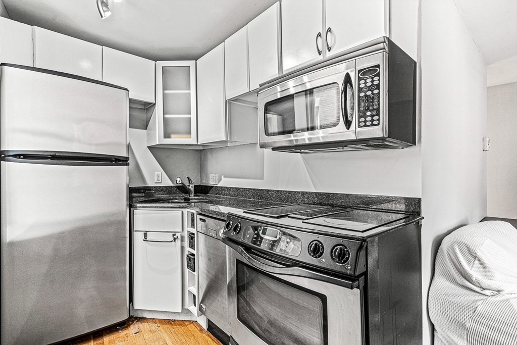 a kitchen with stainless steel appliances granite countertop a stove a refrigerator and a microwave