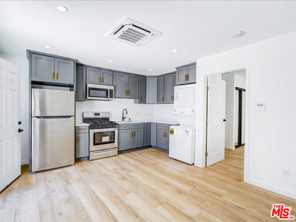 a kitchen with stainless steel appliances a refrigerator sink and cabinets