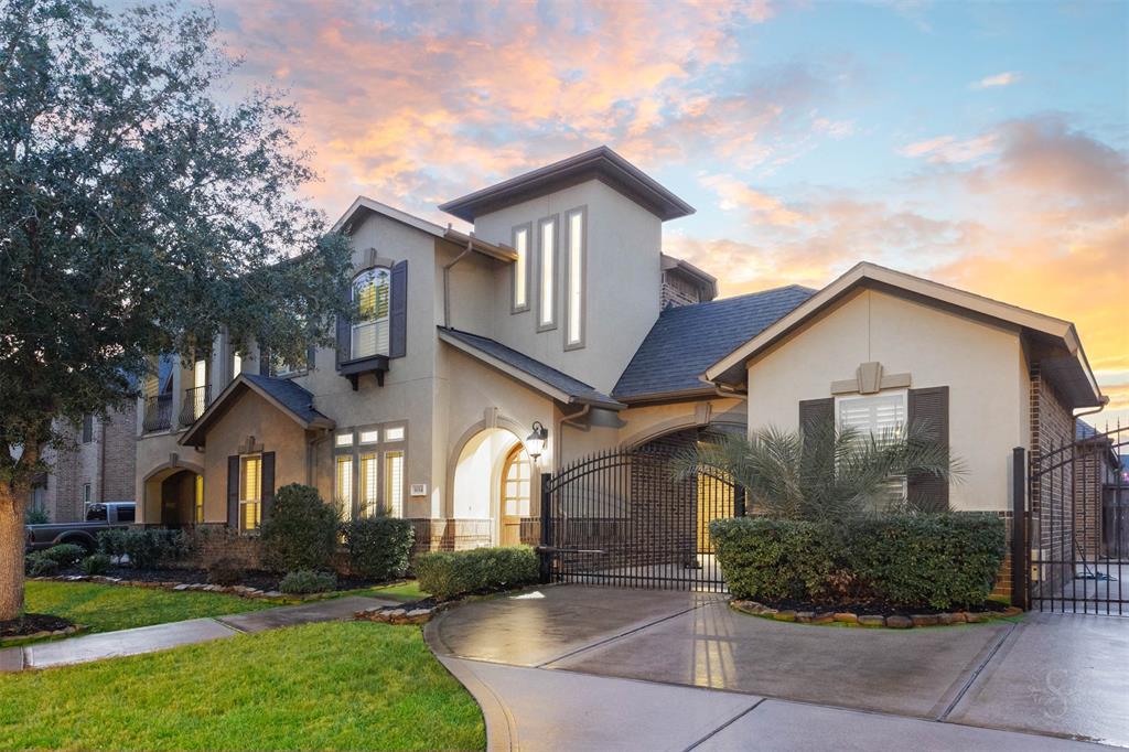 Impressive view of the arched porte cochere with automatic gate that leads to the autocourt and 3 garages. This space provides privacy from street view for your family. Great for small kids at play.