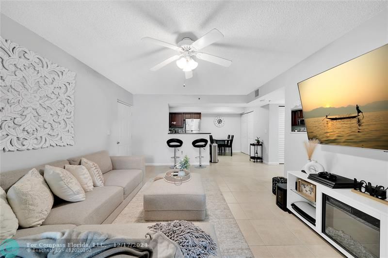 a living room with furniture and view of kitchen