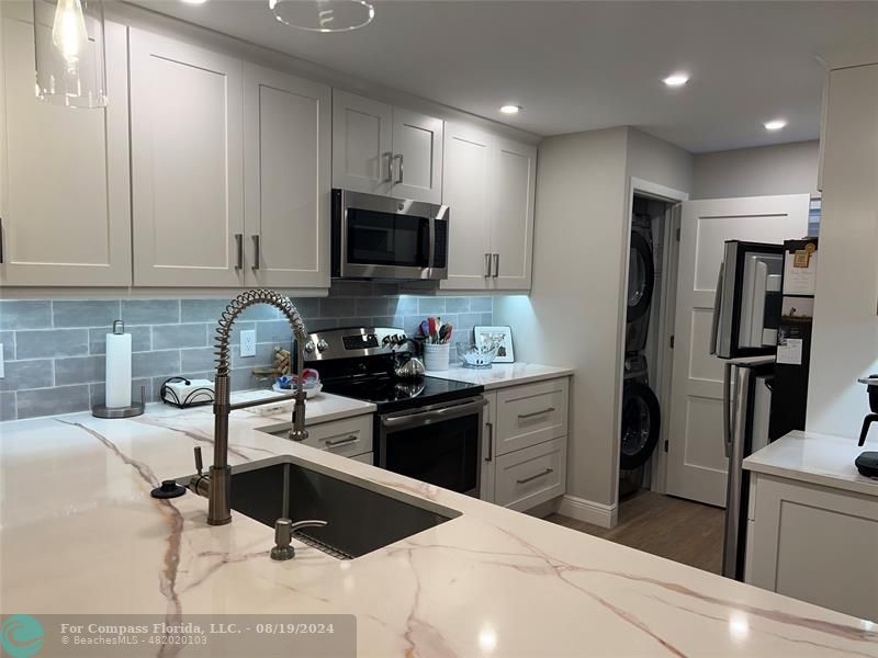 a kitchen with a sink cabinets and stainless steel appliances