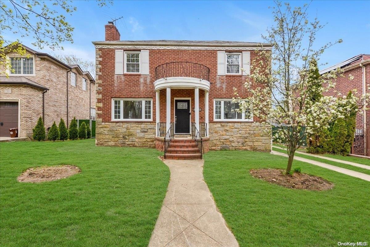 a front view of a house with a garden and yard