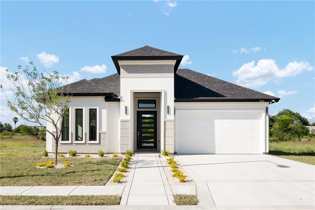 View of front of home with a front lawn and a garage