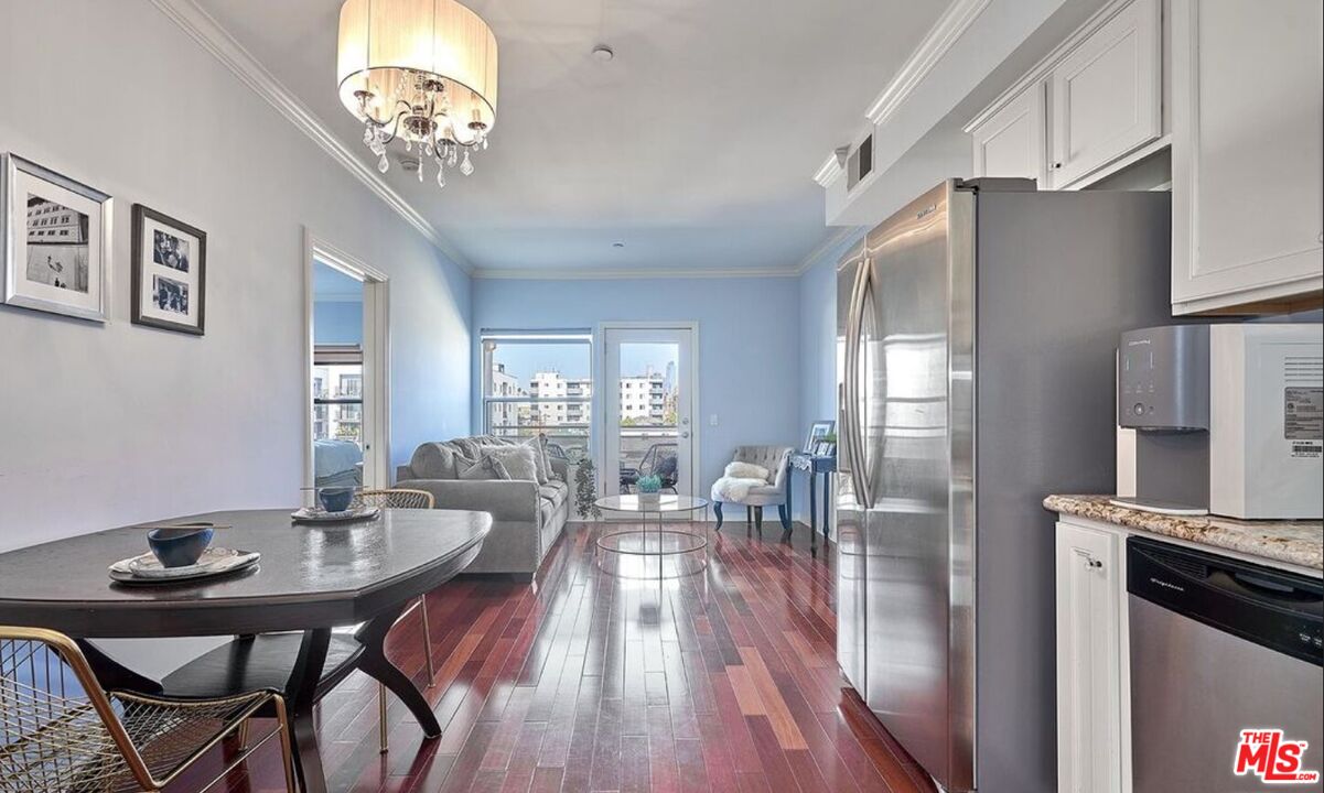 a view of a dining room with furniture a chandelier and wooden floor