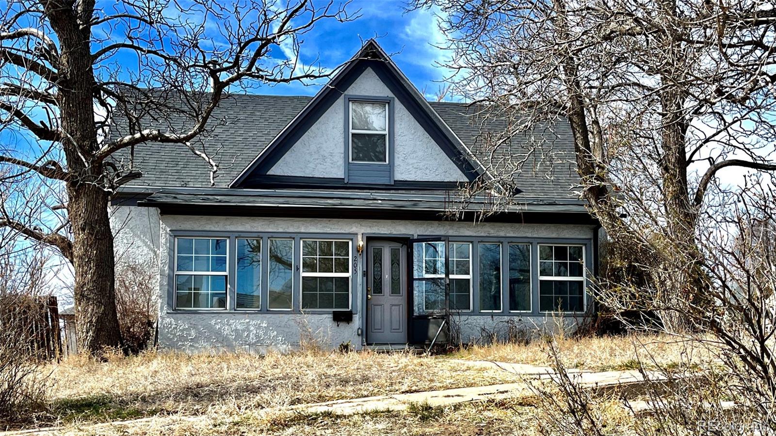 a front view of a house with a yard covered in snow