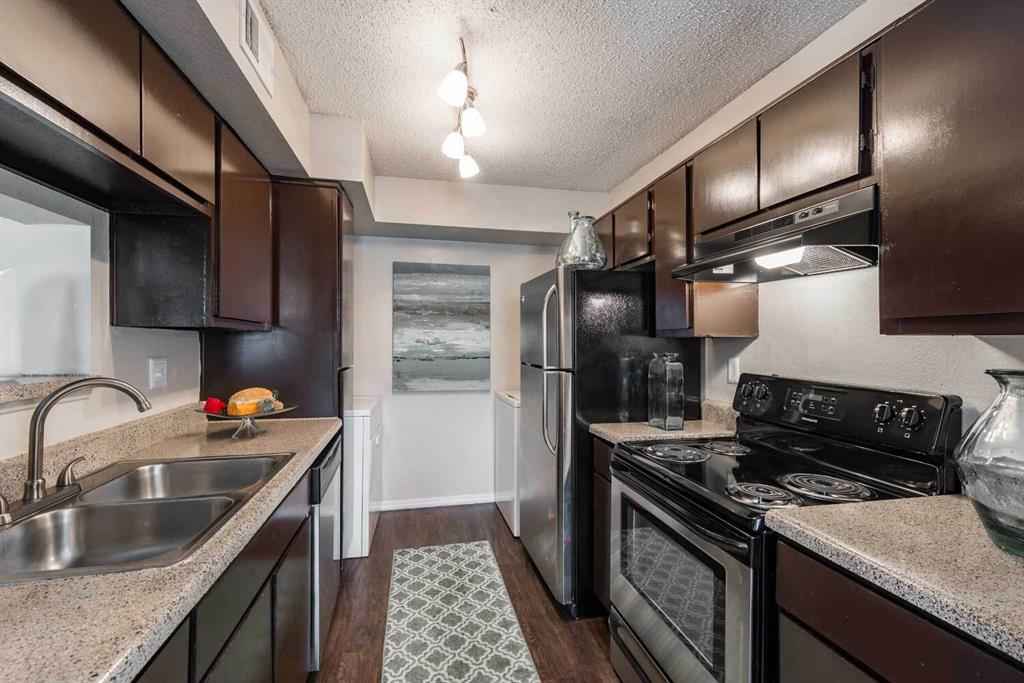 a kitchen with stainless steel appliances granite countertop a sink stove and refrigerator