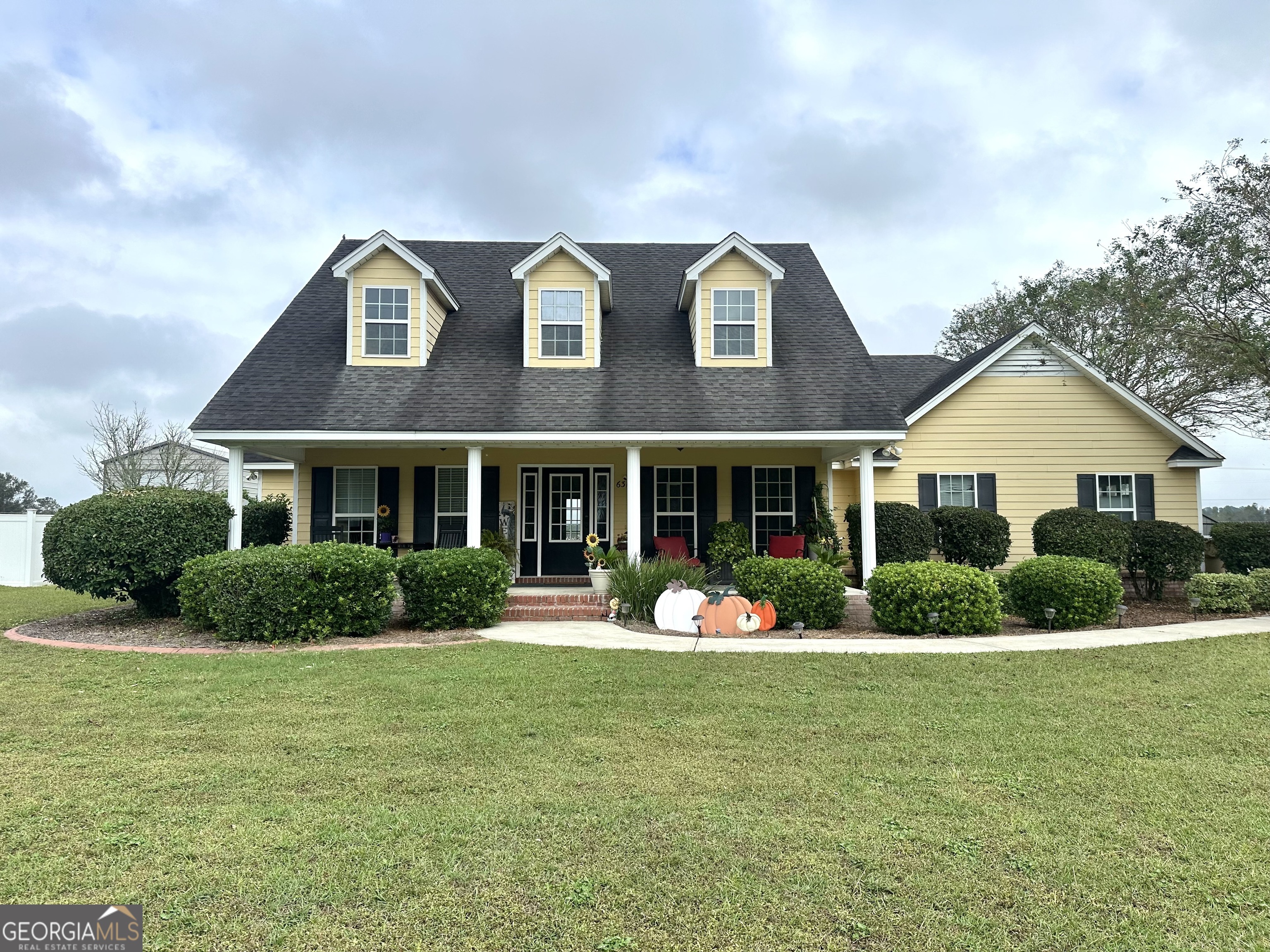 a front view of a house with garden and porch