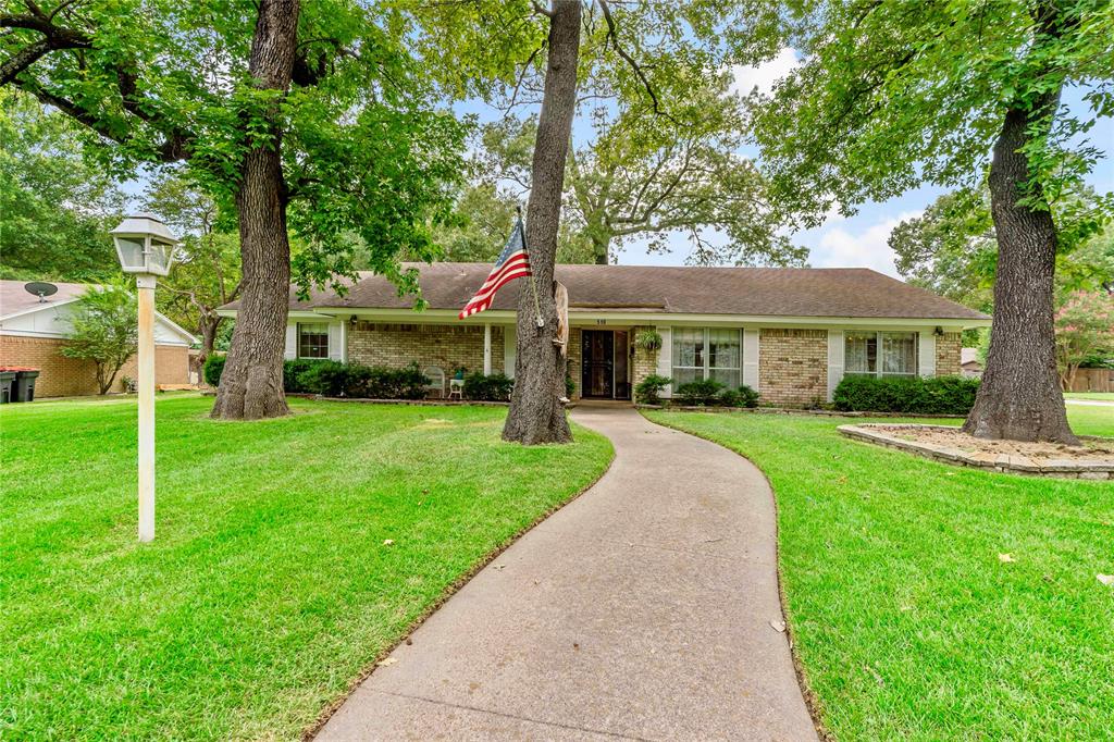 a front view of a house with a yard and trees