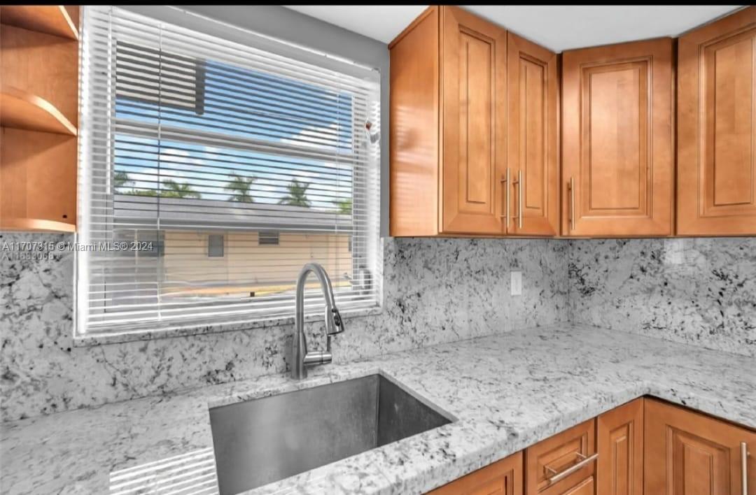 a kitchen with granite countertop a sink and a window