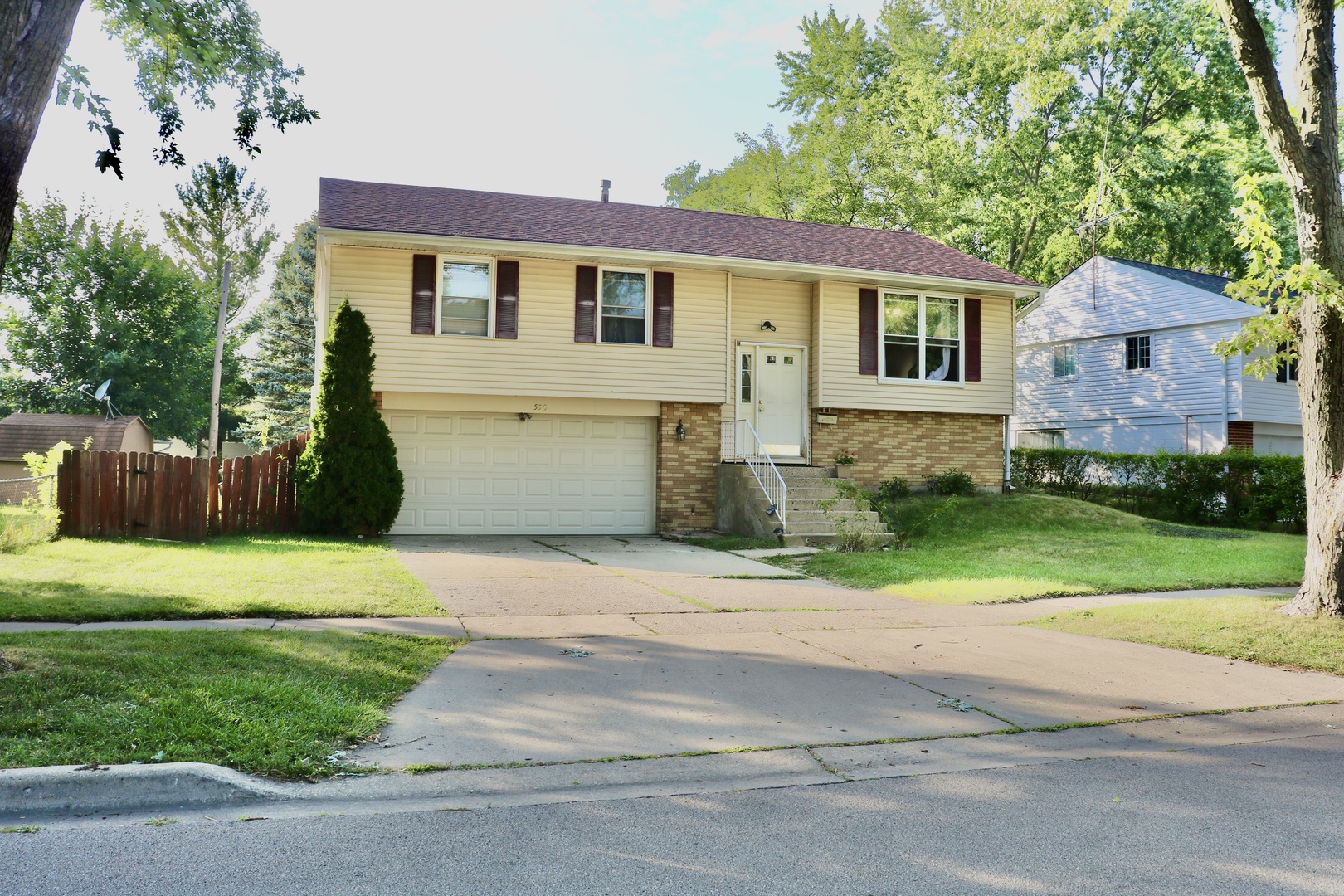 a front view of a house with a yard and a garage