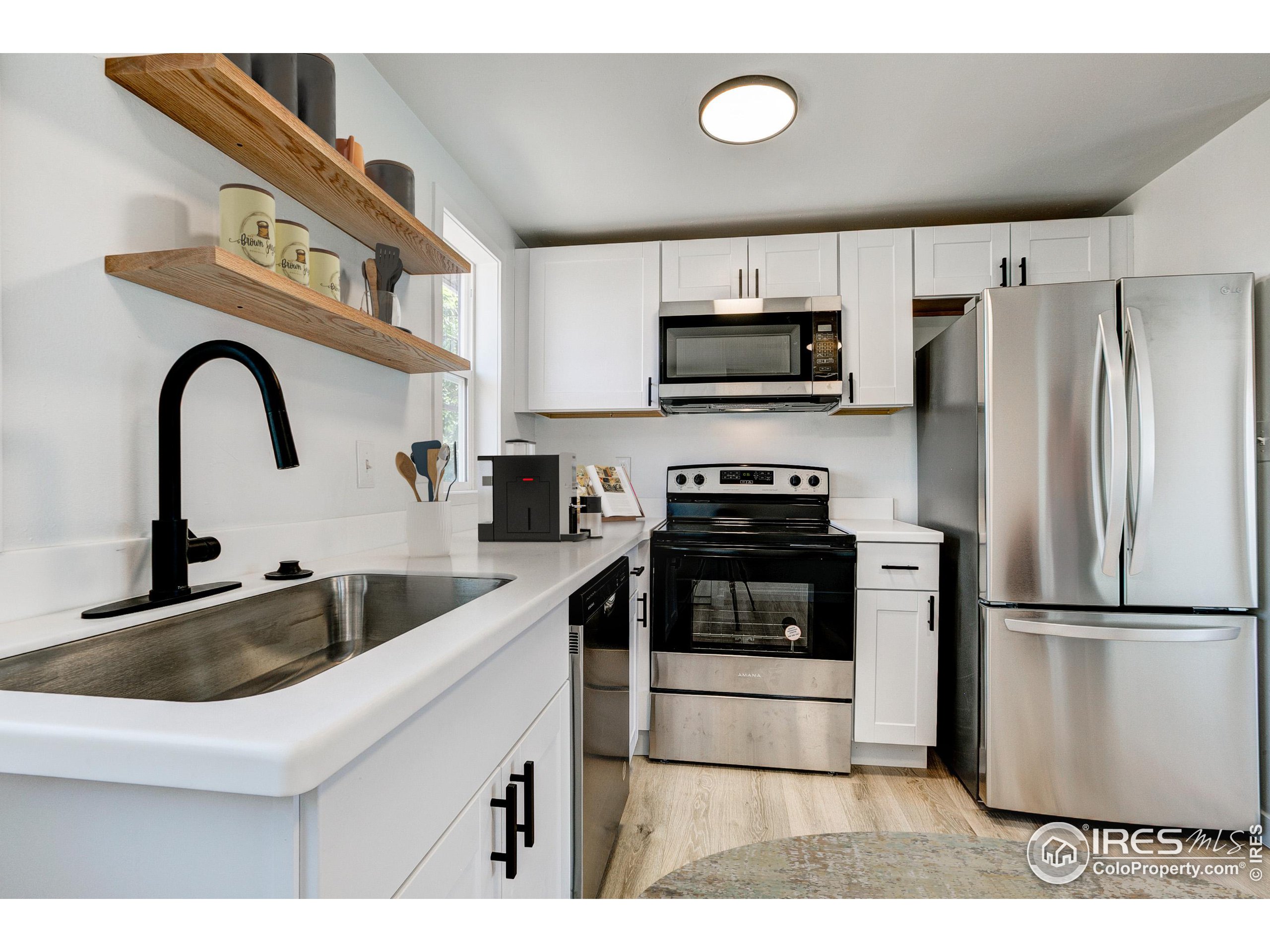 a kitchen with stainless steel appliances a sink a stove a microwave and cabinets