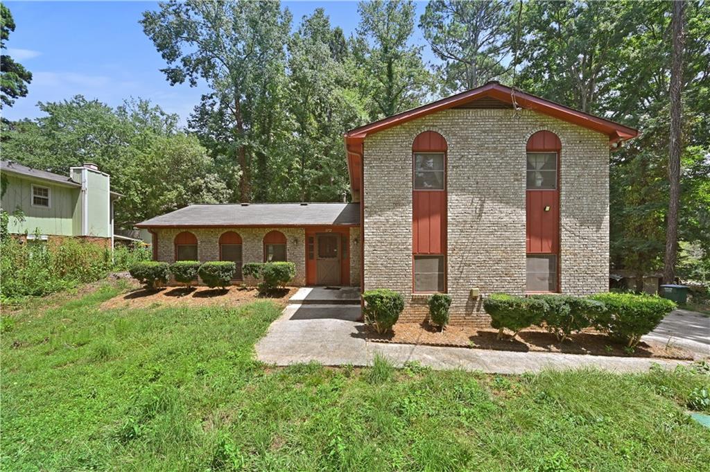 a front view of a house with yard and green space